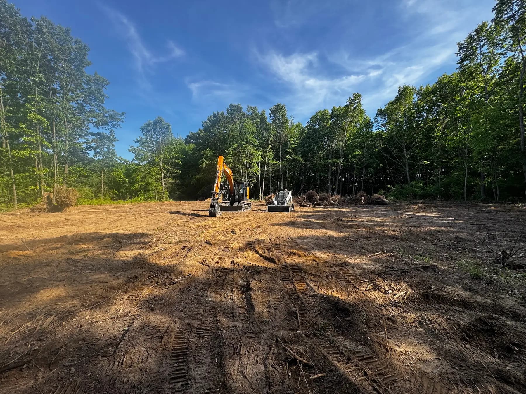 Excavator on a freshly cleared and rough-graded building site